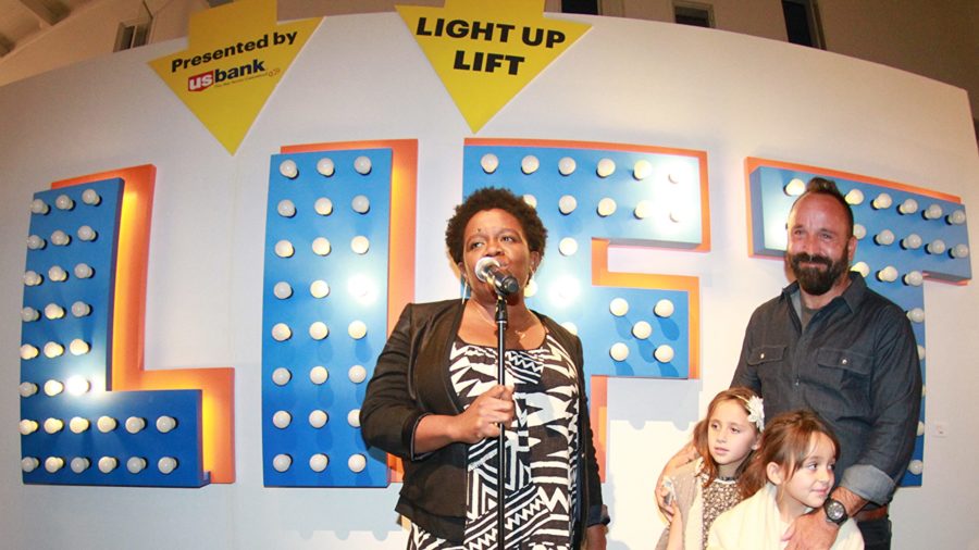 Michelle Rhone Collins with LIFT sign at LIFT:ART Event